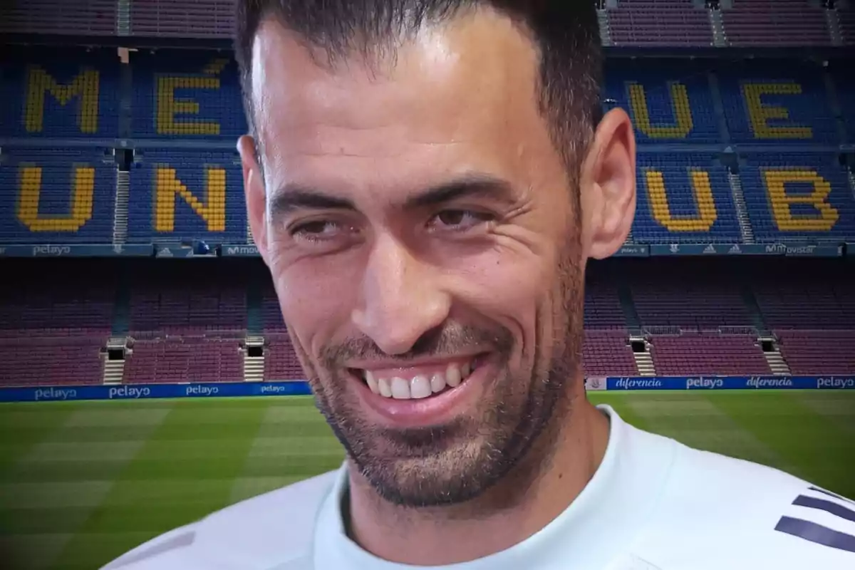 A smiling man in a football stadium.