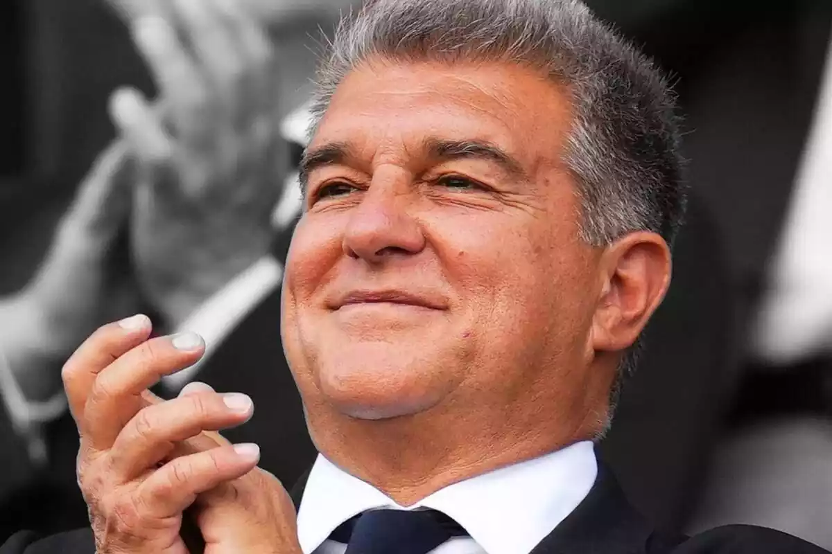 Joan Laporta applauds with a smile on his face on a black and white background