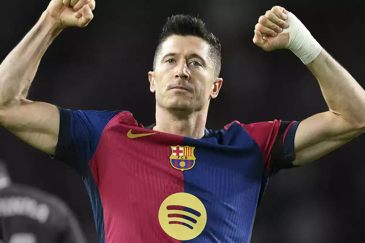 Robert Lewandowski in an FC Barcelona uniform raises his arms in celebration.